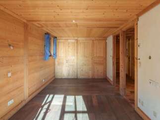 Step into this inviting space, featuring warm wooden walls and flooring that create a cozy atmosphere.