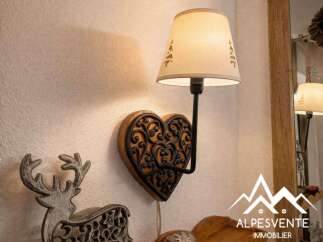 This charming property features a unique heart-shaped wall lamp, adding a touch of rustic elegance.