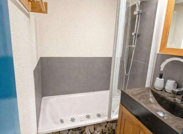 Discover this charming bathroom featuring a modern shower and a relaxing bathtub.