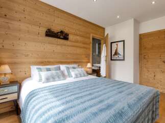 Experience the charm of this cozy bedroom featuring a stunning wooden accent wall.
