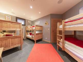 This cozy bedroom features multiple bunk beds, perfect for accommodating a large family or group of friends.