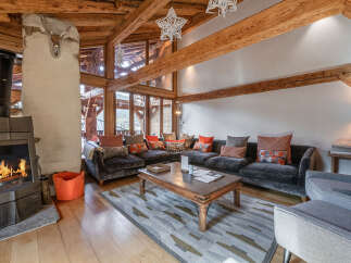 Experience the warmth of this stunning living space, featuring a cozy fireplace and exposed wooden beams that exude rustic charm.