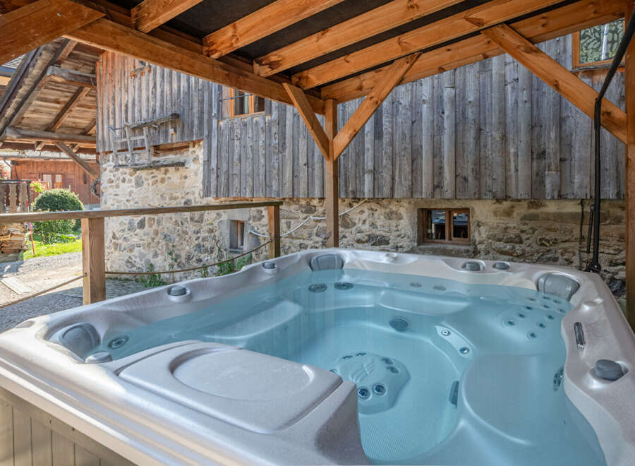 Relax and unwind in this luxurious hot tub, perfectly situated under a rustic wooden structure.