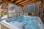 Relax and unwind in this luxurious hot tub, perfectly situated under a rustic wooden structure.