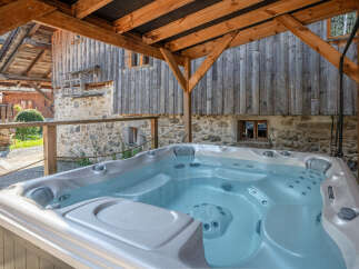Relax and unwind in this luxurious hot tub, perfectly situated under a rustic wooden structure.