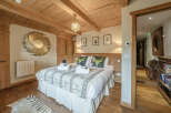Step into luxury with this stunning bedroom, featuring a cozy bed adorned with plush pillows and a stylish throw.