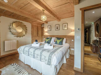 Step into luxury with this stunning bedroom, featuring a cozy bed adorned with plush pillows and a stylish throw.