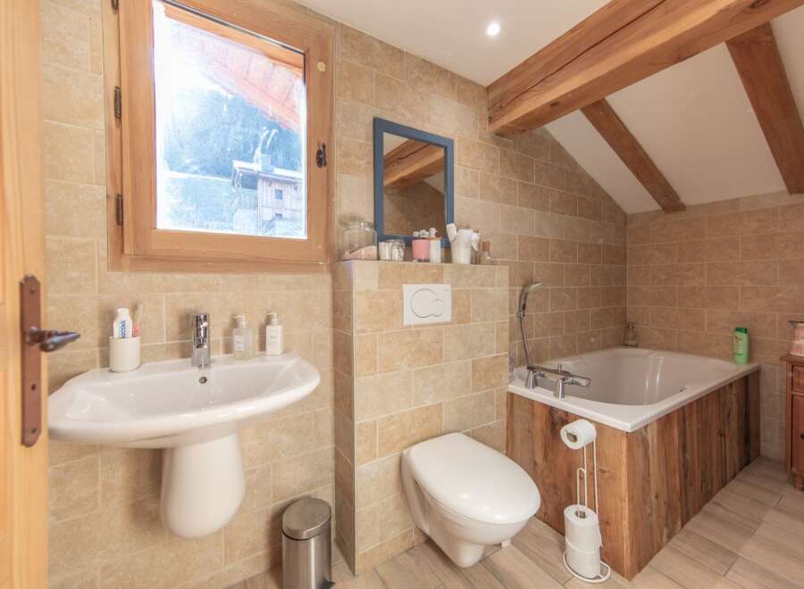 This charming bathroom features a rustic design with wooden accents and a cozy atmosphere.