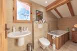 This charming bathroom features a rustic design with wooden accents and a cozy atmosphere.