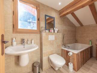 This charming bathroom features a rustic design with wooden accents and a cozy atmosphere.