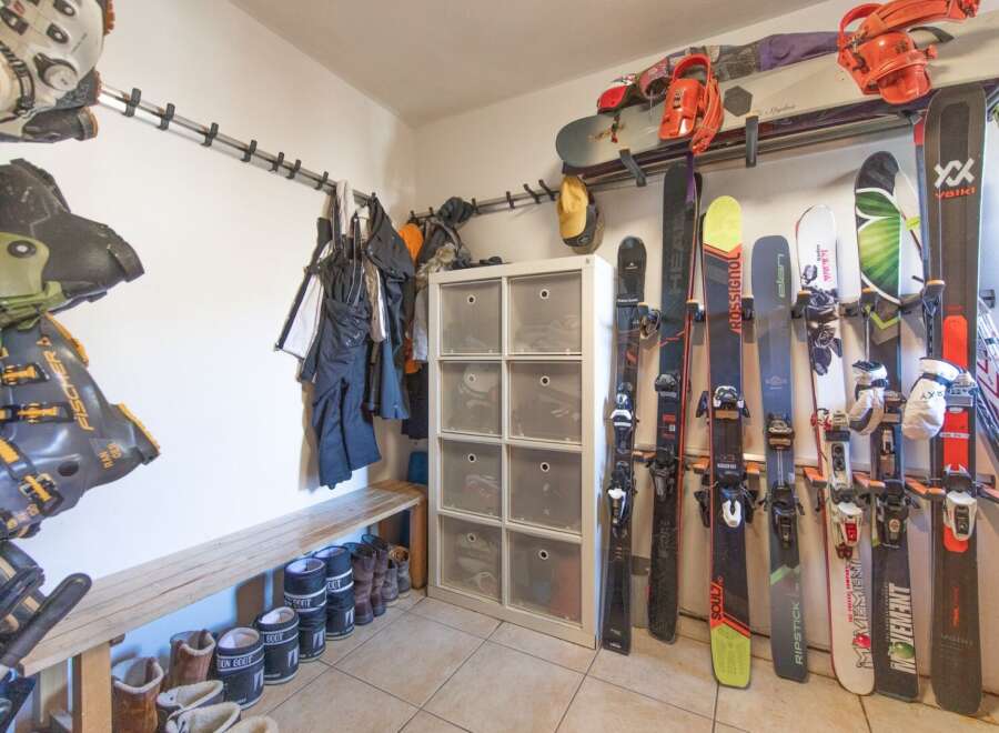 Organize your gear in style with this well-equipped ski storage room! Featuring a convenient bench, ample storage for boots and equipment, and a dedicated space for skis, this room is perfect for any winter sports enthusiast.