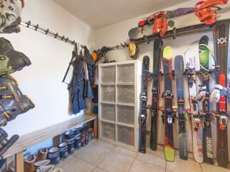 Organize your gear in style with this well-equipped ski storage room! Featuring a convenient bench, ample storage for boots and equipment, and a dedicated space for skis, this room is perfect for any winter sports enthusiast.
