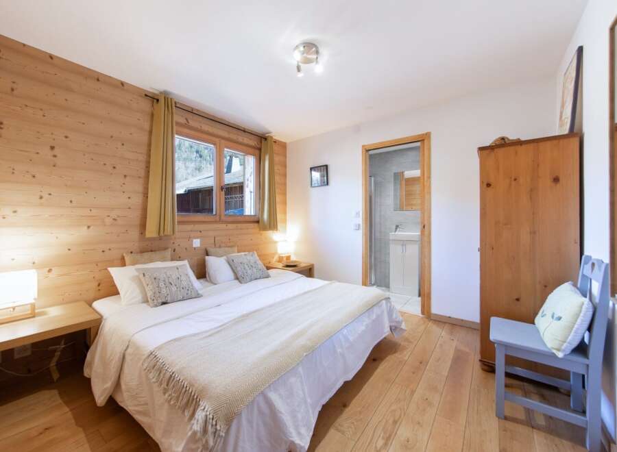 Discover the charm of this cozy bedroom, featuring warm wooden accents and a comfortable double bed.