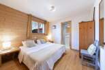 Discover the charm of this cozy bedroom, featuring warm wooden accents and a comfortable double bed.
