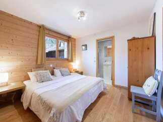 Discover the charm of this cozy bedroom, featuring warm wooden accents and a comfortable double bed.