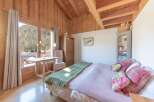 This charming bedroom boasts a cozy ambiance with its wooden walls and ceiling, creating a warm and inviting atmosphere.
