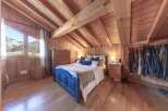 Experience the charm of this cozy bedroom, featuring a unique wooden ceiling and walls that create a warm and inviting atmosphere.