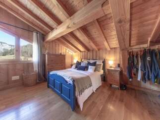 Experience the charm of this cozy bedroom, featuring a unique wooden ceiling and walls that create a warm and inviting atmosphere.