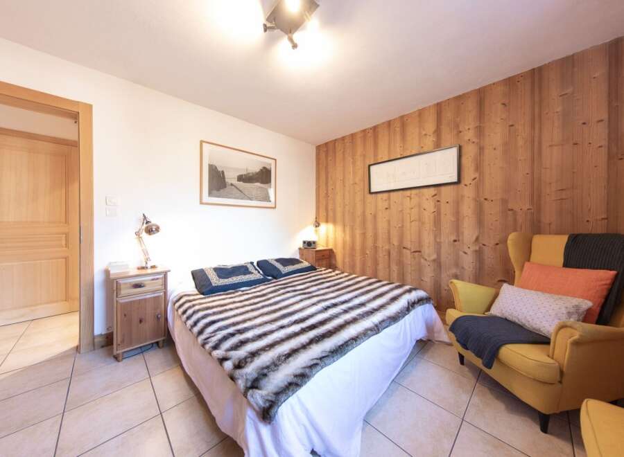 This cozy bedroom features a comfortable bed with a stylish fur throw, perfect for relaxing after a long day.
