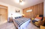 This cozy bedroom features a comfortable bed with a stylish fur throw, perfect for relaxing after a long day.