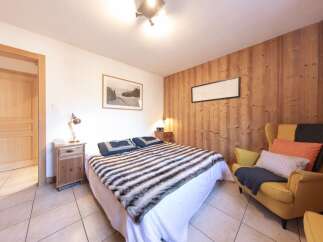 This cozy bedroom features a comfortable bed with a stylish fur throw, perfect for relaxing after a long day.