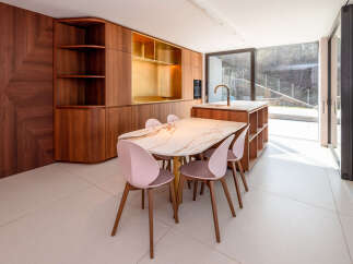 This stunning property features a modern kitchen with custom cabinetry and a luxurious marble dining table.