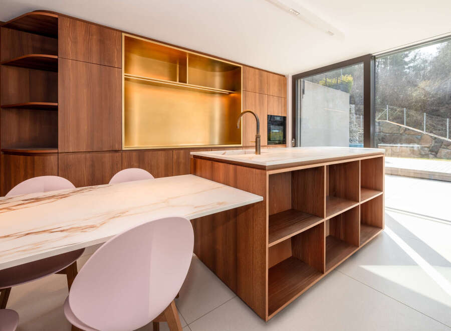 This stunning kitchen boasts a modern design with sleek wooden cabinetry and a luxurious marble countertop.