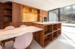 This stunning kitchen boasts a modern design with sleek wooden cabinetry and a luxurious marble countertop.