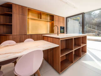 This stunning kitchen boasts a modern design with sleek wooden cabinetry and a luxurious marble countertop.