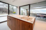 This stunning modern kitchen boasts a sleek design with a beautiful marble countertop and rich wood cabinetry.