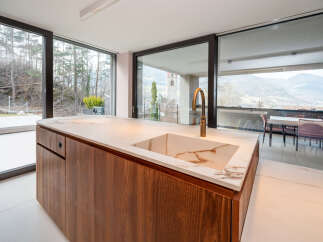 This stunning modern kitchen boasts a sleek design with a beautiful marble countertop and rich wood cabinetry.