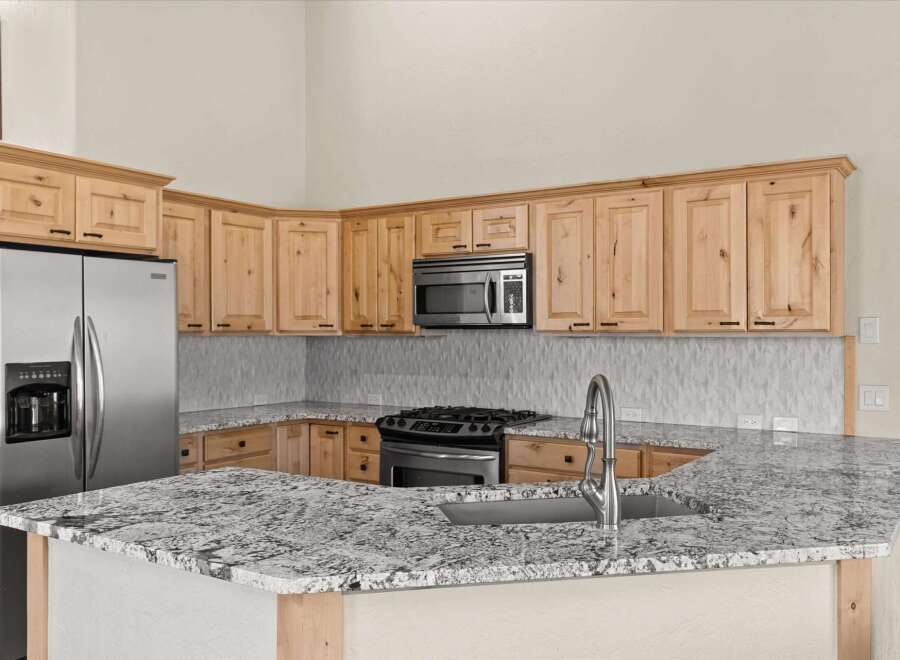 This stunning kitchen boasts beautiful wooden cabinetry and a sleek stainless steel refrigerator.