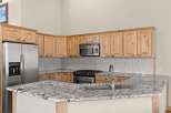 This stunning kitchen boasts beautiful wooden cabinetry and a sleek stainless steel refrigerator.
