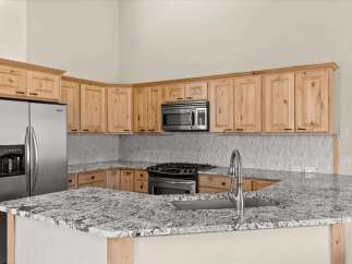 This stunning kitchen boasts beautiful wooden cabinetry and a sleek stainless steel refrigerator.