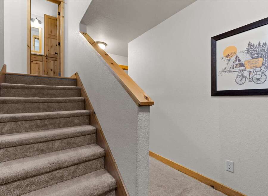 This inviting staircase leads to a cozy interior, featuring warm wooden accents and plush carpeting.