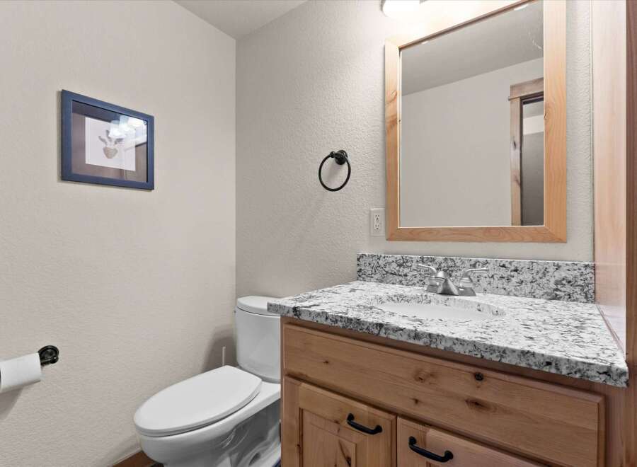 Step into this beautifully designed bathroom, featuring a stylish vanity with a granite countertop and ample storage.