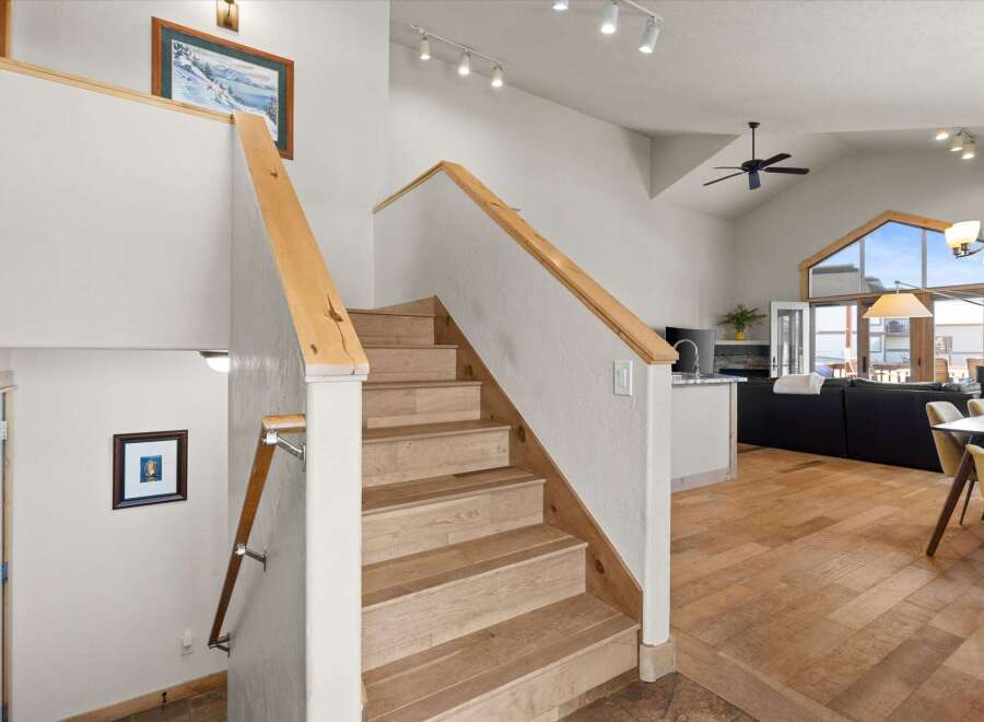 This stunning property boasts a beautiful staircase with natural wood accents, leading to a bright and airy living space.
