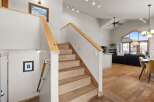 This stunning property boasts a beautiful staircase with natural wood accents, leading to a bright and airy living space.
