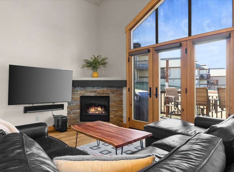 Experience luxury living in this stunning property featuring a cozy fireplace and a sleek, modern TV setup.