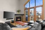 Experience luxury living in this stunning property featuring a cozy fireplace and a sleek, modern TV setup.