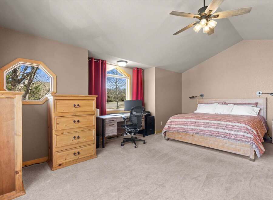 This inviting bedroom boasts a cozy ambiance with its neutral color palette and ample natural light.