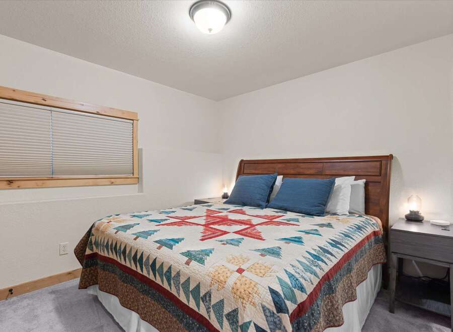 This cozy bedroom features a comfortable bed with a unique quilt, perfect for a relaxing retreat.