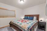 This cozy bedroom features a comfortable bed with a unique quilt, perfect for a relaxing retreat.