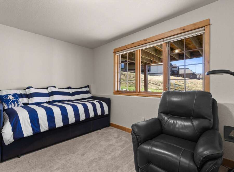Discover the comfort of this inviting bedroom, featuring a stylish daybed with blue and white striped bedding.