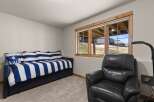 Discover the comfort of this inviting bedroom, featuring a stylish daybed with blue and white striped bedding.