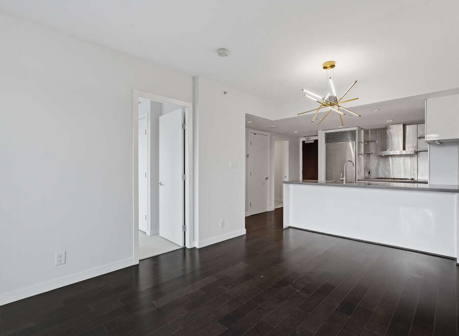 This modern apartment boasts a sleek, open-concept design with a gourmet kitchen featuring stainless steel appliances.