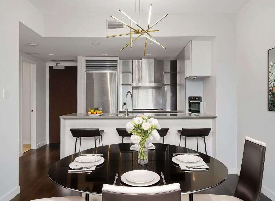 Experience luxury living in this stunning modern condo! Featuring a sleek, stainless steel kitchen with a breakfast bar, perfect for entertaining.