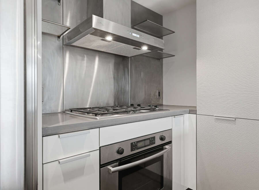 This modern kitchen boasts sleek stainless steel appliances and a minimalist design, perfect for contemporary living.