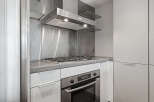 This modern kitchen boasts sleek stainless steel appliances and a minimalist design, perfect for contemporary living.