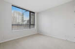 This bright and airy room features a large window with blinds, offering stunning city views and ample natural light.